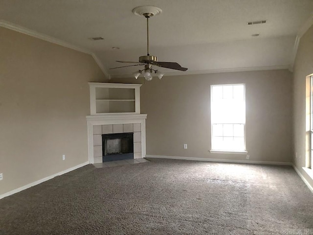 unfurnished living room featuring a tile fireplace, carpet flooring, vaulted ceiling, and ceiling fan