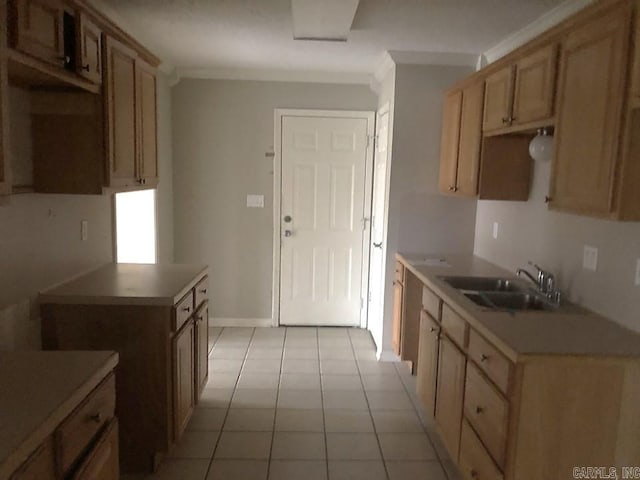 kitchen with light tile patterned floors, ornamental molding, and sink