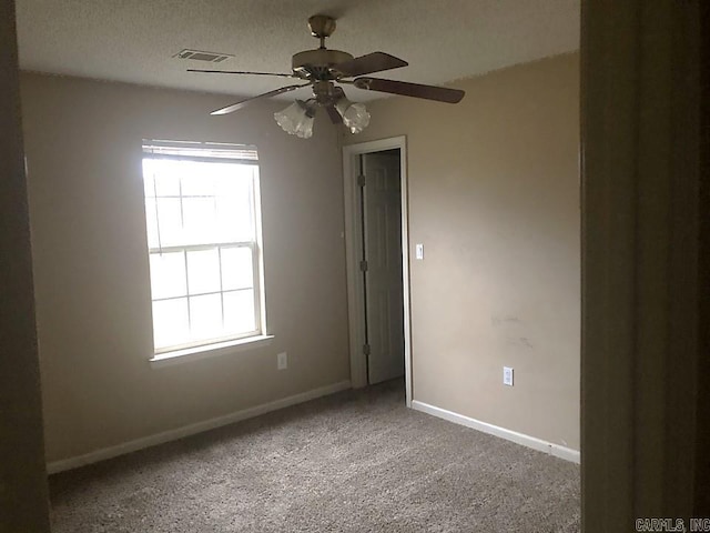 carpeted empty room featuring a textured ceiling and ceiling fan