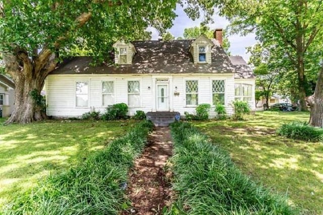 new england style home featuring a front yard