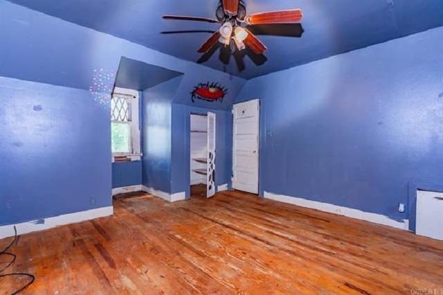 unfurnished bedroom featuring hardwood / wood-style flooring, ceiling fan, and lofted ceiling