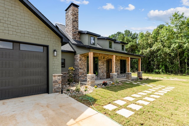 exterior space featuring a lawn, covered porch, and a garage