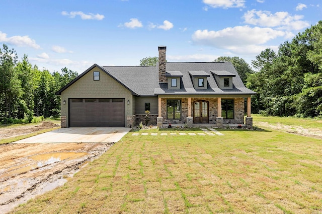 view of front of home with a garage, covered porch, and a front yard