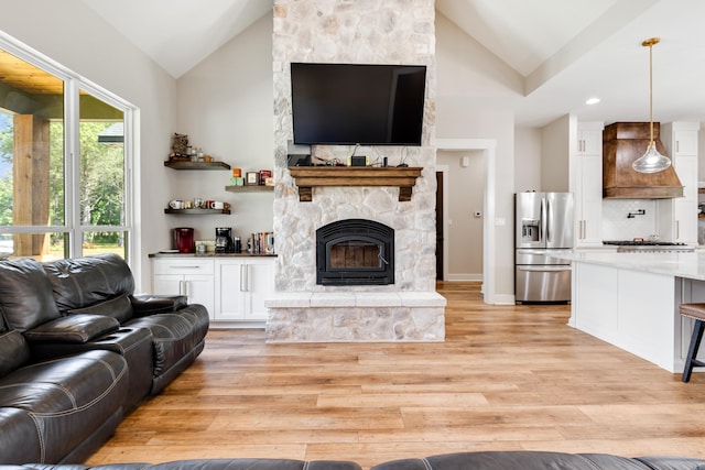 living room featuring a fireplace, light hardwood / wood-style floors, and lofted ceiling