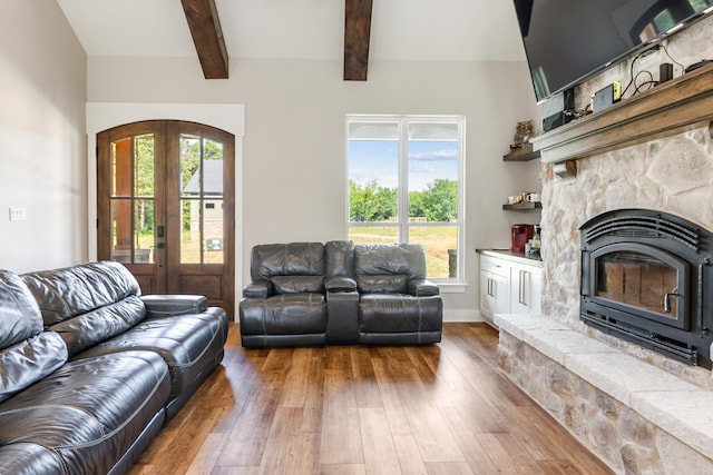 living room with beam ceiling, french doors, plenty of natural light, and hardwood / wood-style flooring