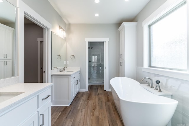 bathroom with hardwood / wood-style flooring, vanity, and independent shower and bath