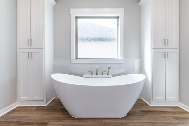 bathroom featuring a washtub and hardwood / wood-style floors