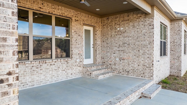 doorway to property with ceiling fan and a patio area