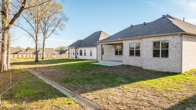 rear view of house with a patio and a lawn