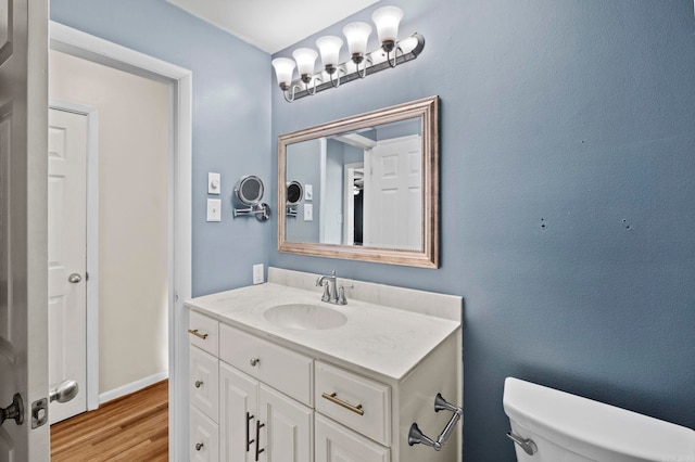 bathroom with hardwood / wood-style floors, vanity, and toilet