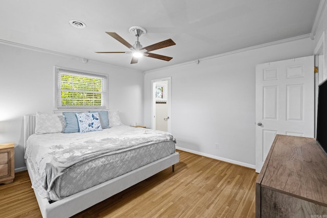 bedroom with ceiling fan, light wood-type flooring, and ornamental molding