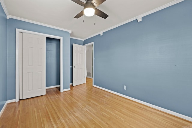 unfurnished bedroom with a closet, ceiling fan, crown molding, and light hardwood / wood-style floors