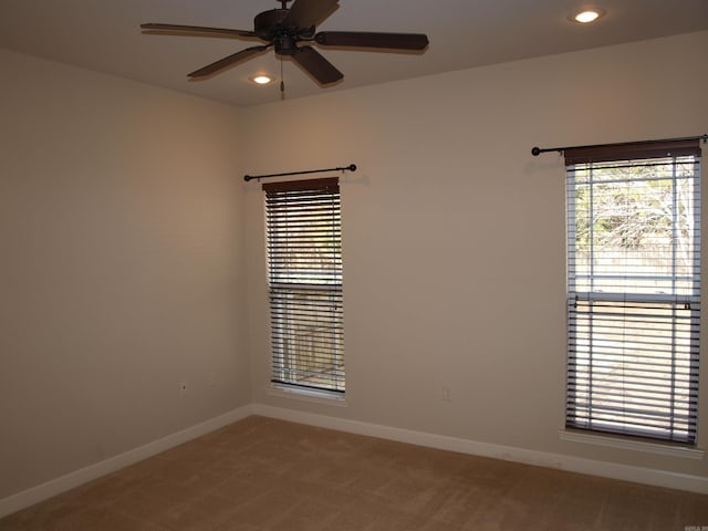 carpeted spare room featuring ceiling fan