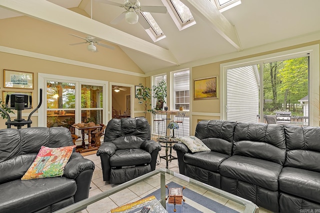 living room with ceiling fan, a skylight, a wealth of natural light, and light tile patterned flooring