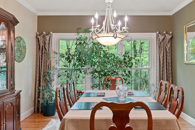 dining room featuring ornamental molding, light wood-type flooring, and a notable chandelier