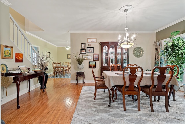 dining area featuring crown molding, light hardwood / wood-style floors, and ceiling fan with notable chandelier