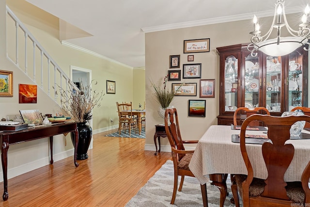 dining space featuring a notable chandelier, crown molding, and light hardwood / wood-style flooring