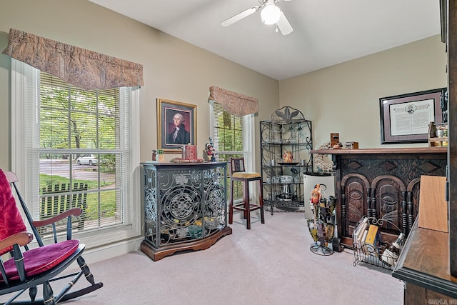 living area featuring light carpet, plenty of natural light, and ceiling fan