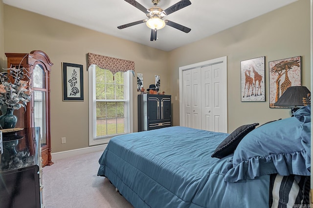 carpeted bedroom featuring ceiling fan and a closet