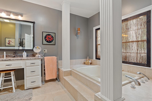 bathroom featuring tile patterned flooring, vanity, a relaxing tiled tub, and ornate columns