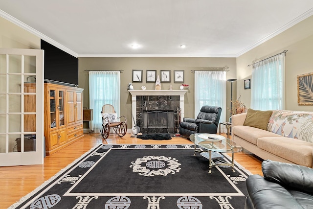 living room with hardwood / wood-style flooring, ornamental molding, and a high end fireplace