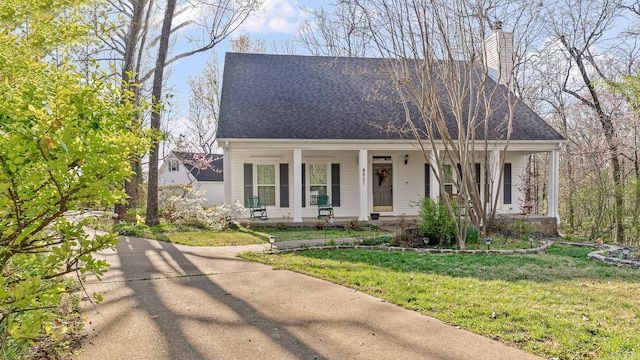 cape cod house featuring covered porch and a front yard