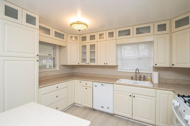 kitchen with plenty of natural light, white cabinetry, sink, and white appliances