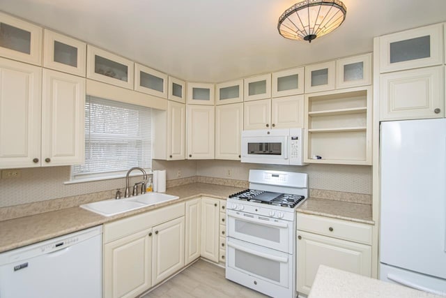 kitchen with white appliances, sink, and hanging light fixtures