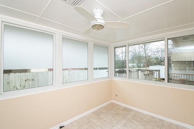 unfurnished sunroom featuring ceiling fan