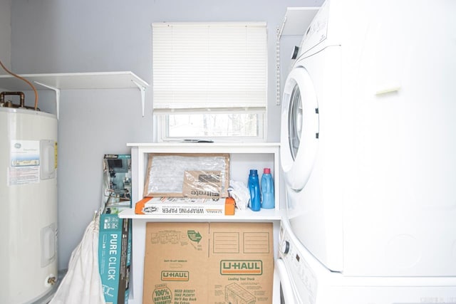 clothes washing area featuring electric water heater and stacked washer and clothes dryer