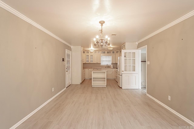 kitchen with white refrigerator, ornamental molding, light hardwood / wood-style flooring, and a chandelier