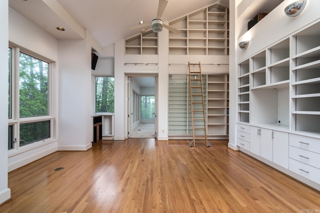 unfurnished bedroom with light wood-type flooring, high vaulted ceiling, and multiple windows