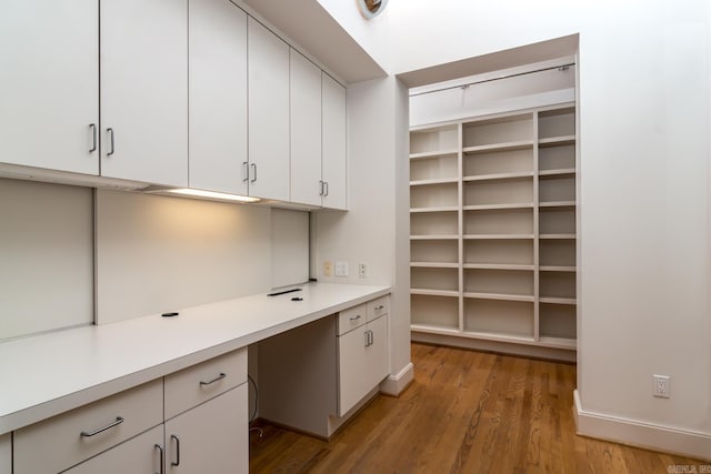 unfurnished office with light wood-type flooring and built in desk