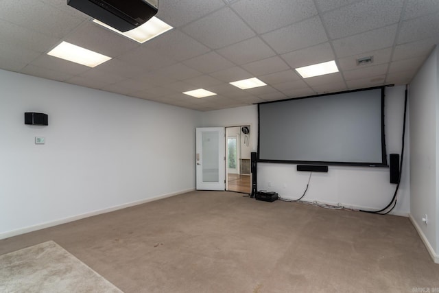 carpeted cinema room featuring a drop ceiling