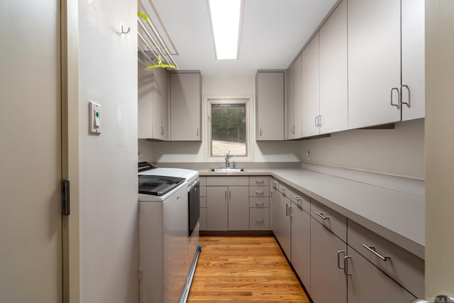 kitchen featuring gray cabinetry, washer and clothes dryer, light wood-type flooring, and sink