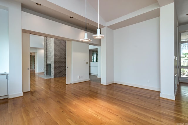 interior space featuring a fireplace, wood-type flooring, and lofted ceiling