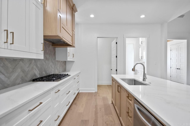 kitchen featuring appliances with stainless steel finishes, light wood-type flooring, white cabinetry, and sink