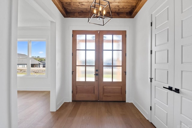 entryway featuring wood-type flooring, wooden ceiling, a wealth of natural light, and french doors