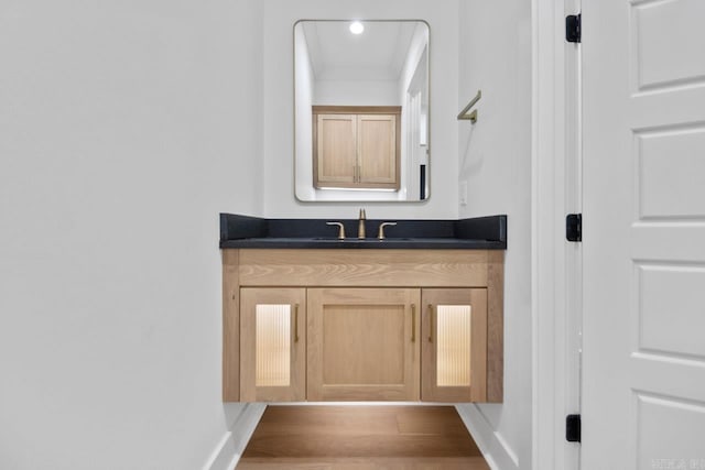 bathroom featuring crown molding, vanity, and wood-type flooring