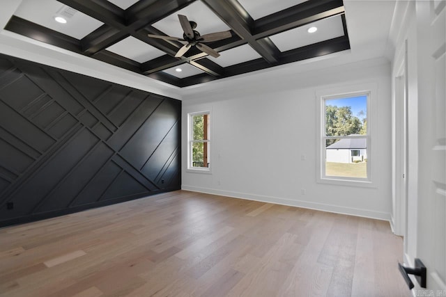 unfurnished room with beamed ceiling, light hardwood / wood-style flooring, a wealth of natural light, and coffered ceiling