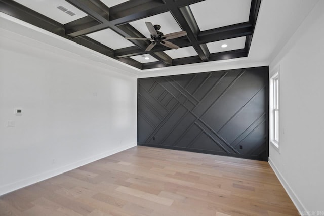 unfurnished room featuring beamed ceiling, a healthy amount of sunlight, light hardwood / wood-style floors, and coffered ceiling