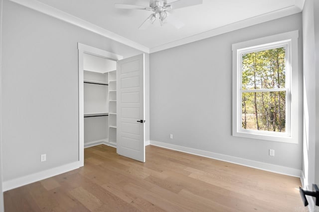 unfurnished bedroom featuring a closet, light hardwood / wood-style floors, ceiling fan, and ornamental molding