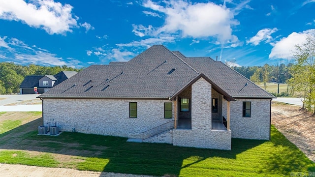 rear view of property featuring a yard and cooling unit