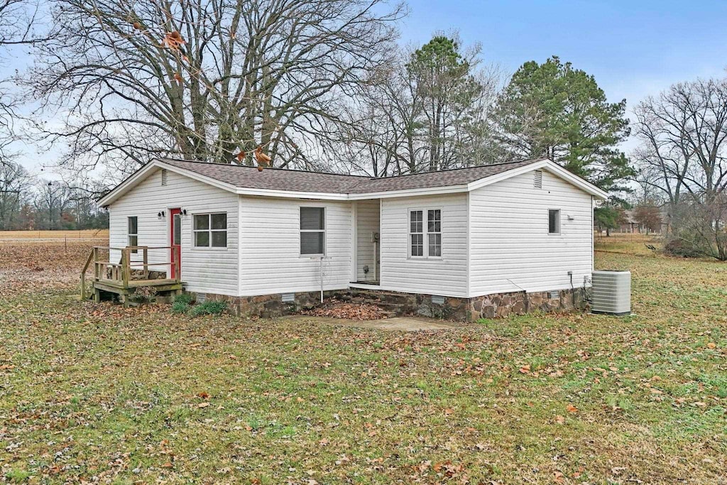 view of front of house featuring a front lawn and central AC