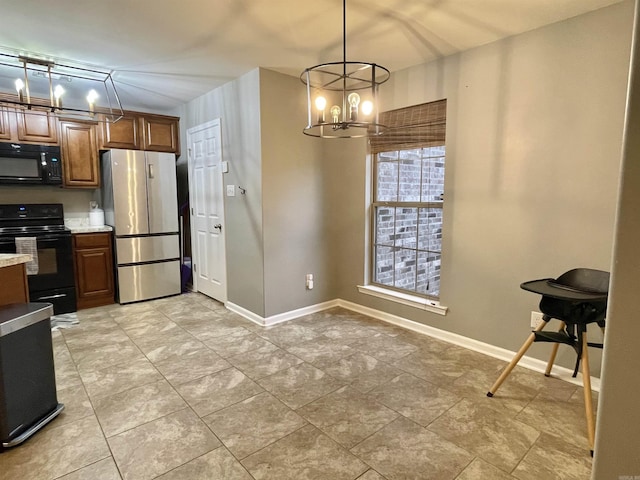 kitchen featuring a chandelier, pendant lighting, light stone countertops, and black appliances