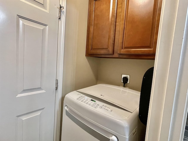 clothes washing area with cabinets and washer / clothes dryer