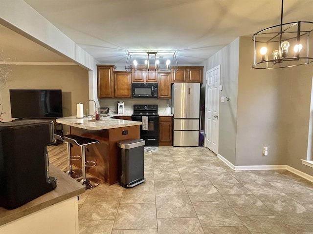 kitchen featuring a breakfast bar, black appliances, a notable chandelier, a kitchen island, and hanging light fixtures