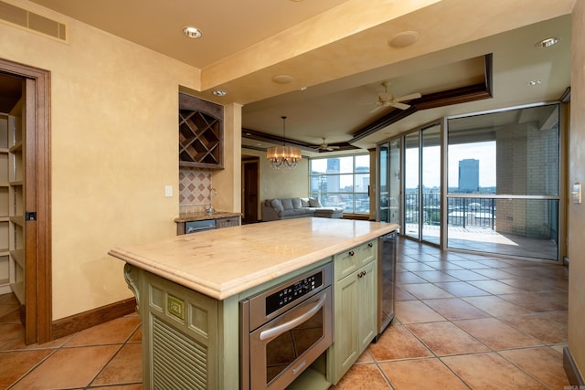 kitchen featuring ceiling fan, hanging light fixtures, floor to ceiling windows, a center island, and oven