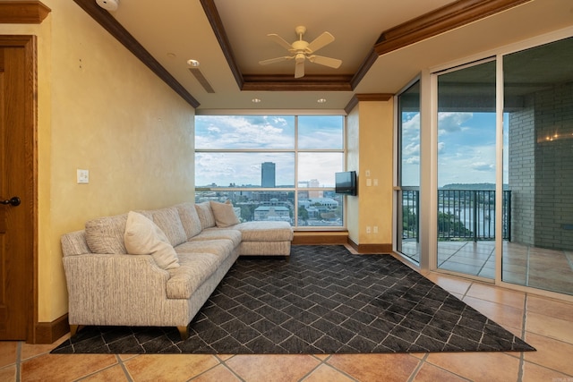 living room featuring a raised ceiling, crown molding, tile patterned floors, and ceiling fan