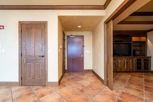 hallway featuring built in shelves, crown molding, and light tile patterned flooring